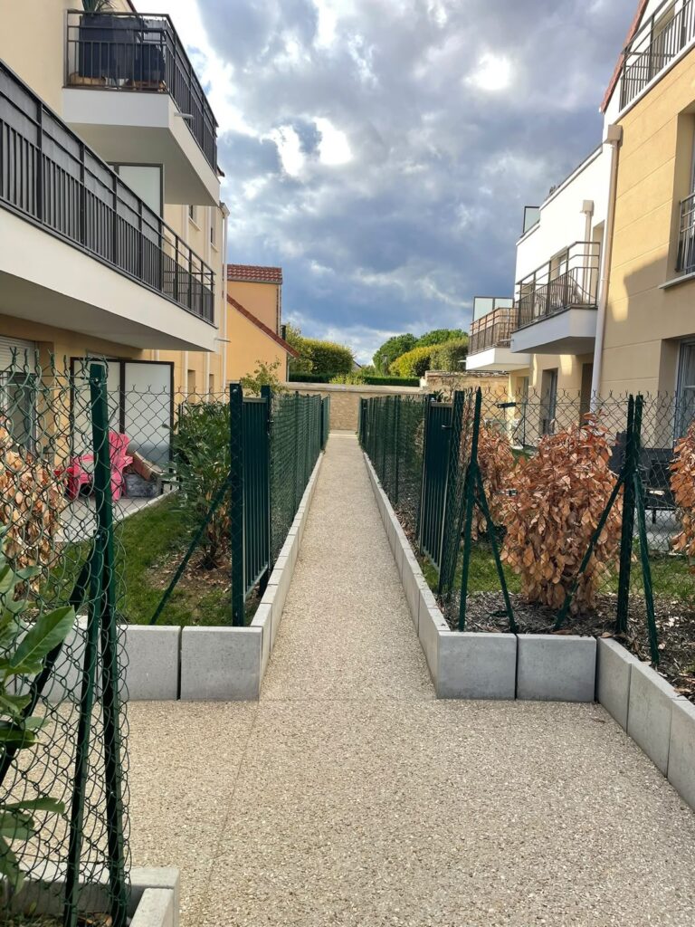 Allée de résidence désherbée bordée de haies entretenues