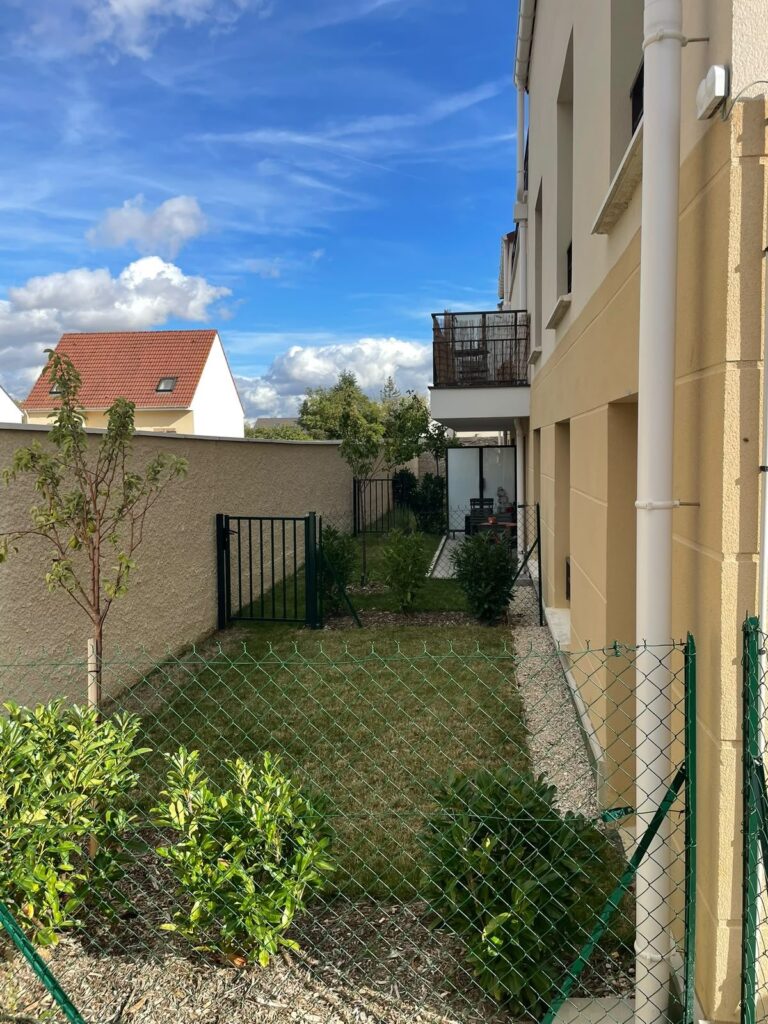Jardin privatif de copropriété : pelouse tondue et arbustes taillés
