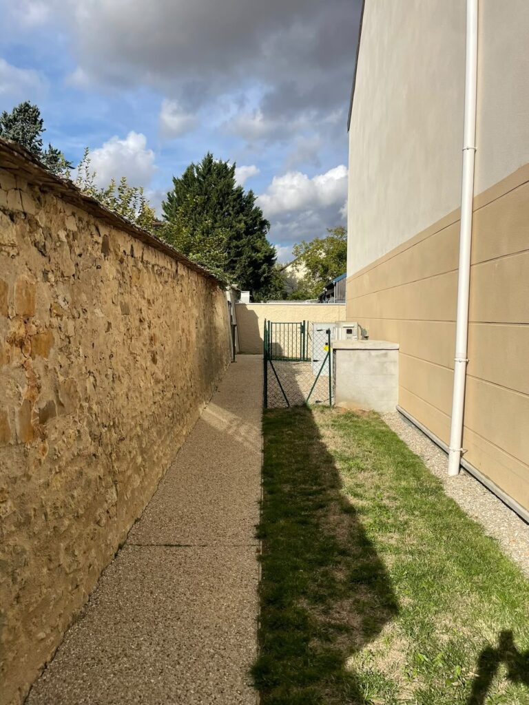 Passage engazonné tondu le long d’une résidence